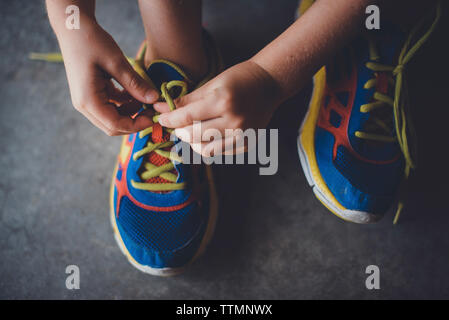 7/8 die Hände des jungen Schnürsenkel binden Stockfoto