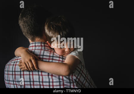 Ansicht der Rückseite des Mann mit Sohn gegen Wand Stockfoto