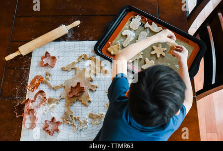 Overhead shot Hände Kind, das Cookies mit ausstechformen. Stockfoto