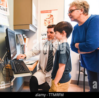 Arzt, Kind und ältere Frau Informationen auf dem Bildschirm. Stockfoto