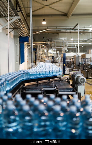 Wasserflaschen auf Transportband im Werk Stockfoto