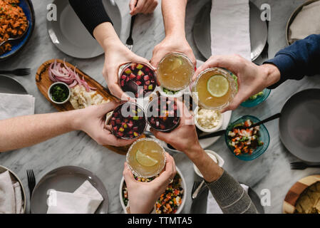 7/8 Hände der Freunde toasten Getränke am Tisch Stockfoto