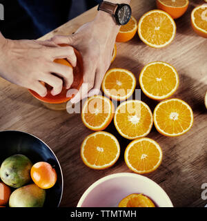 Direkt über der Hände quetschen Orangen Stockfoto