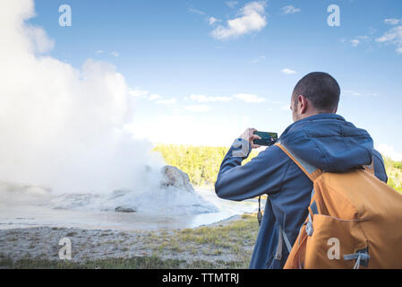 Rückansicht des Menschen fotografieren, während gegen Sky standing Stockfoto