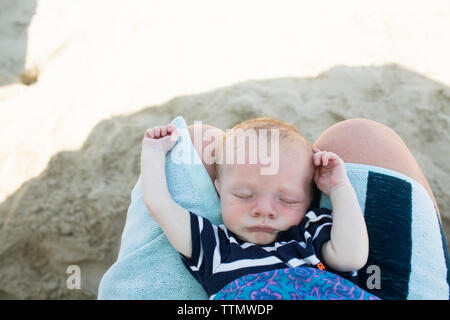 Mittelteil der Mutter mit dem neugeborenen Sohn am Strand Stockfoto