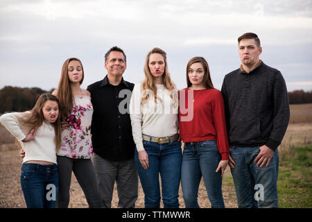 Closeup Big Family macht Dumme Gesichter, In Bauernhof Feld bei Sonnenuntergang Stockfoto