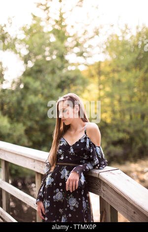 Schwere Teenager stehen auf einer Brücke vor Green Woods Stockfoto