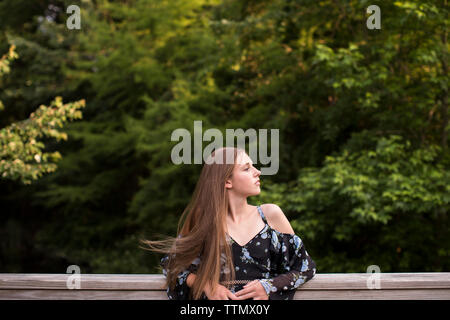 Wind bläst Haar der schönen jugendlich Mädchen stehen auf einer Brücke in Holz Stockfoto