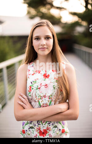 Headshot von schönen jungen Mädchen auf der Brücke mit verschränkten Armen Stockfoto