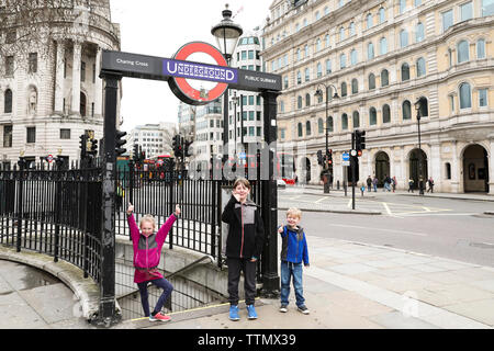Drei Geschwister Posieren vor U-Zeichen auf die London Street Stockfoto