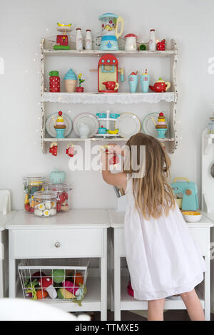 Ansicht der Rückseite des Girl holding Teekanne beim Spielen in playhouse Stockfoto