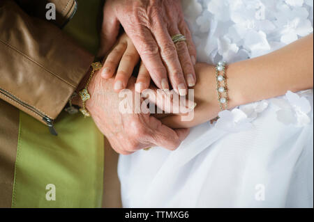 Mittelteil der Großmutter halten sich an den Händen der Enkelin während der Gemeinschaft Stockfoto