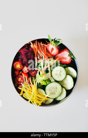 Ansicht von oben von frischem Salat in der Schüssel gegen weißen Hintergrund Stockfoto