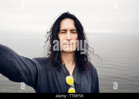 Portrait von Mensch gegen Meer Stockfoto