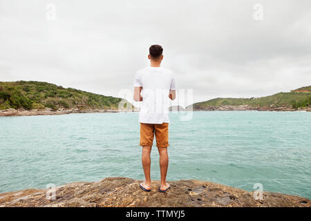 Ansicht der Rückseite des jungen Mann stand am Seeufer Stockfoto