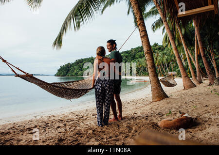 Liebespaar steht die Hängematte am Strand Stockfoto