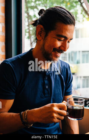 Lächelnd reifer Mann mit schwarzen Kaffee im Cafe Stockfoto