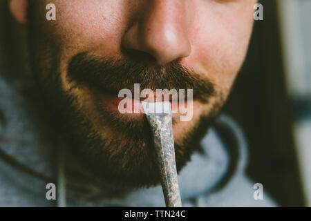 Mittelteil der bärtige Mann Marihuana joint im mund Stockfoto