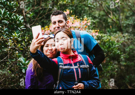 Gerne Freunde unter selfie beim Stehen in Wald Stockfoto