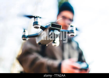 Low Angle View der Wanderer flying Quadcopter stehend gegen den klaren Himmel Stockfoto