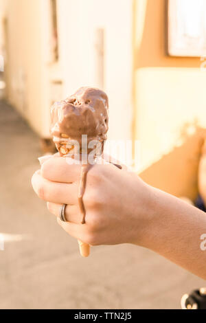7/8 Hand der Frau mit schmelzenden Eis Stockfoto
