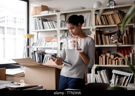 Innenarchitekt holding Coffee Mug, bei der Dateien im Office Stockfoto