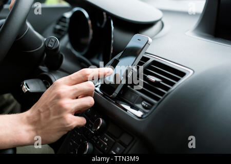 Männliche hand mit GPS auf Smartphones im Auto. Stockfoto