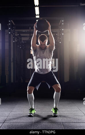 Bestimmt männlichen Athleten trainieren mit einem medizinball in der Turnhalle Stockfoto