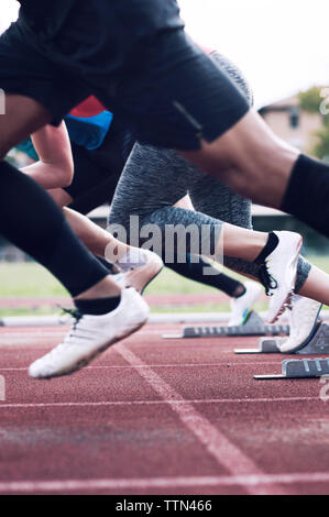 Athleten sprinten aus startlöchern am Anschluss Stockfoto