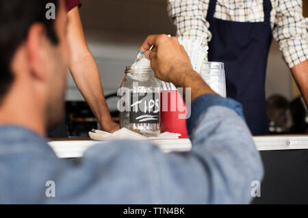 Ansicht der Rückseite des Kunden setzen Tipps in den jar in Essen Lkw mit Anbietern Stockfoto