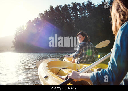 Gerne weibliche Freunde Kajakfahren auf dem See während der sonnigen Tag Stockfoto