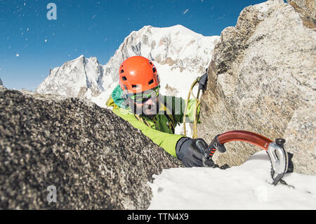 Männliche Wanderer klettern Berg im Winter Stockfoto