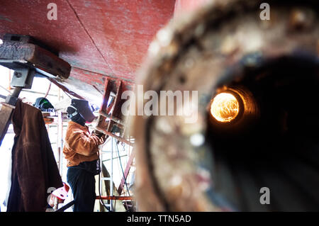 Seitenansicht der Bauarbeiter schweißen Schiff in der Industrie Stockfoto