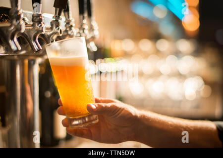 7/8 Hand der Barkeeper Bier Befüllen aus an der Bar tippen Stockfoto