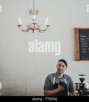 Männliche Besitzer weg schauen, während man gegen die Wand in der Caf  Stockfoto