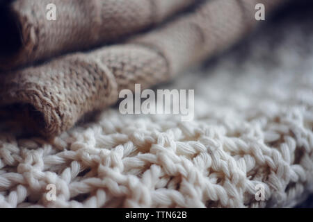 Beige Wollpullover und weißen Jumper große Stricken liegen in einem Stapel übereinander Stockfoto