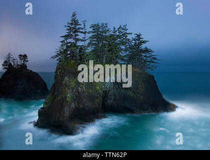 Einen malerischen Blick auf die Bäume wachsen auf Felsen mitten im Meer vor blauem Himmel Stockfoto