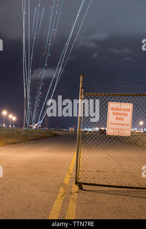 Low Angle View des Lichts Gemälde über Straße gegen bewölkter Himmel bei Nacht Stockfoto