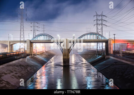 Sixth Street Viadukt über Los Angeles River gegen bewölkter Himmel bei Nacht Stockfoto