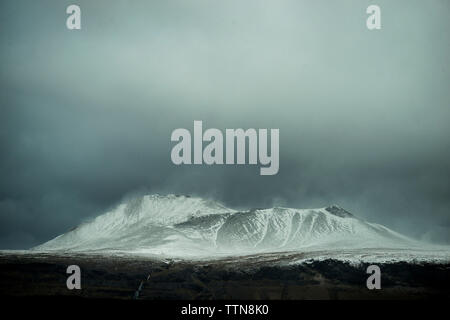 Majestätischen Blick auf schneebedeckte Berge gegen stürmische Wolken Stockfoto