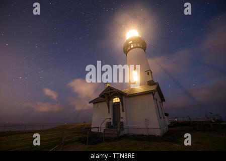 Low Angle majestätischen Blick auf das beleuchtete Leuchtturm gegen star Feld am Kap Blanco State Park Stockfoto