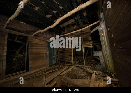 Abgebrochene Holzhaus im Wald bei Nacht Stockfoto