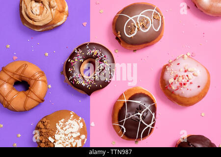 Ansicht der verschiedenen Donuts auf farbigem Hintergrund angeordnet Stockfoto
