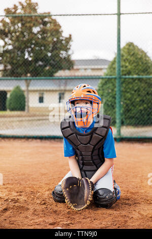 Baseball Catcher kniend auf Feld Stockfoto