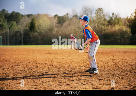 Seitenansicht der Junge spielt Baseball auf Feld Stockfoto