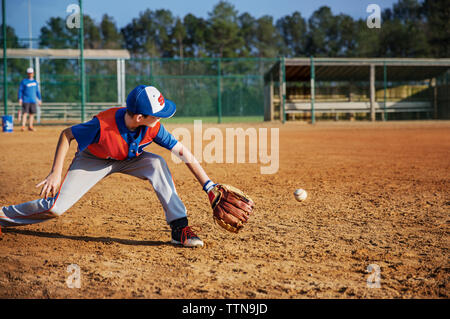 Junge spielt Baseball auf Feld Stockfoto