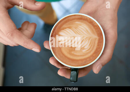 Mann mit Tasse Kaffee mit Latte Art Stockfoto