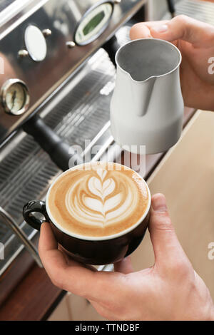 Mann mit Tasse Kaffee mit Latte Art Stockfoto