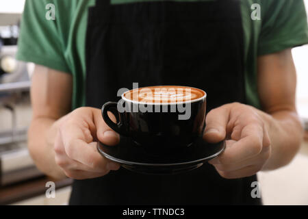 Mann mit Tasse Kaffee mit Latte Art Stockfoto