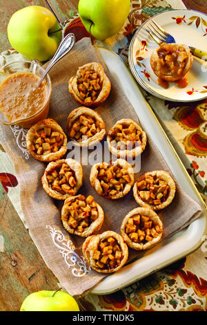 High-Winkel-Ansicht von gebackenen Apfelschalen mit Karamell in Tablett auf dem Tisch zu Hause Stockfoto